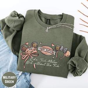 A military green sweatshirt with a graphic design featuring a tow truck and the text "TOW MATTER" and "Like Tuh-Matter, But without the Tuh!"