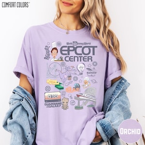 A woman wearing a purple t-shirt with various Disney-themed graphics and text, including a chef, a rocket ship, and other iconic elements associated with the EPCOT Center.