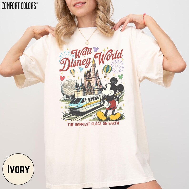 A woman wearing a white t-shirt with a Disney World graphic printed on it.