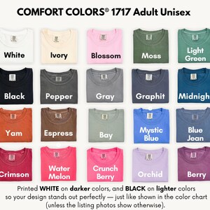 a collection of 1717 adult unisex t-shirts in various colors, including white, ivory, pink, green, black, pepper, gray, graphite, midnight, yam, yam, express, bay, mystical blue, blue jeans, and orchid. The t-shirts are neatly folded and arranged in a grid pattern.