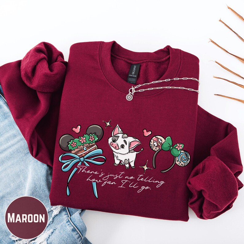 A maroon-colored sweatshirt with a Disney-themed graphic design, including a pig, Mickey Mouse ears, and a ribbon. The text on the sweatshirt says "There's just no telling how fan I'll go".