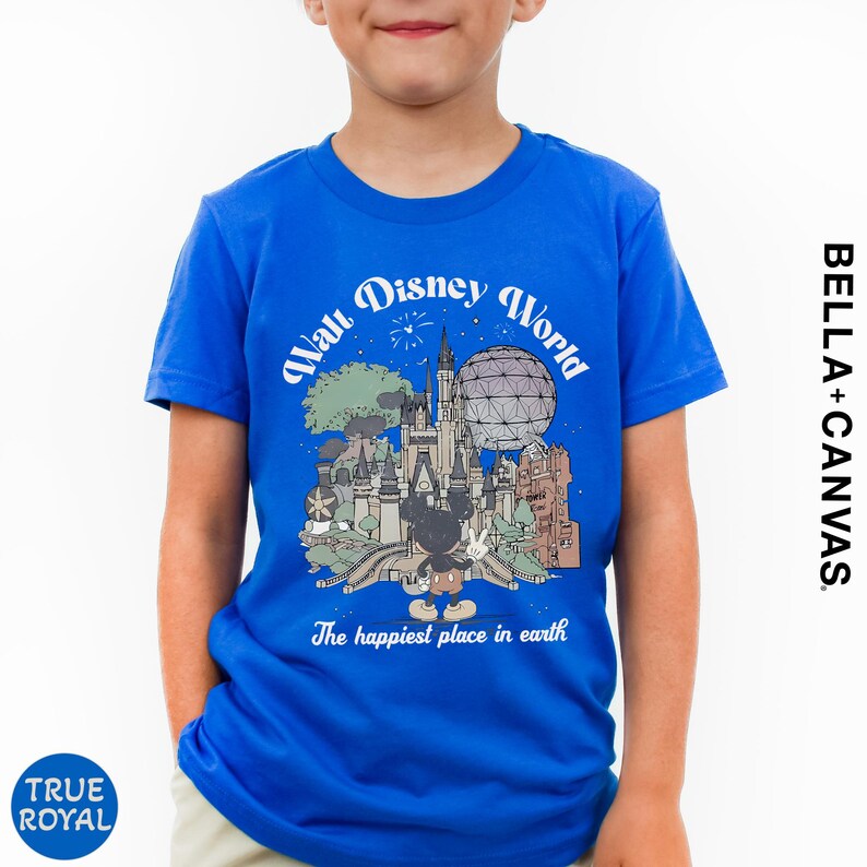 A young boy wearing a blue t-shirt with a graphic of Disney World and the text "The happiest place in earth" printed on it.