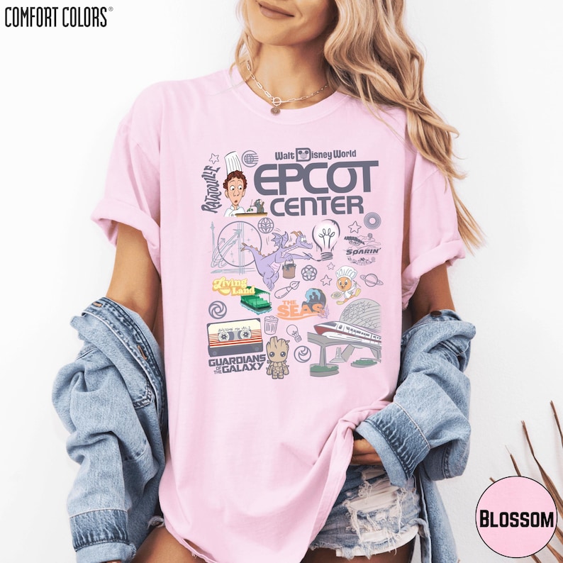 A woman wearing a pink t-shirt with various Disney-themed graphics and text, including the words 'EPCT CENTER', 'Disney World', and 'Garden of the Galaxy'.