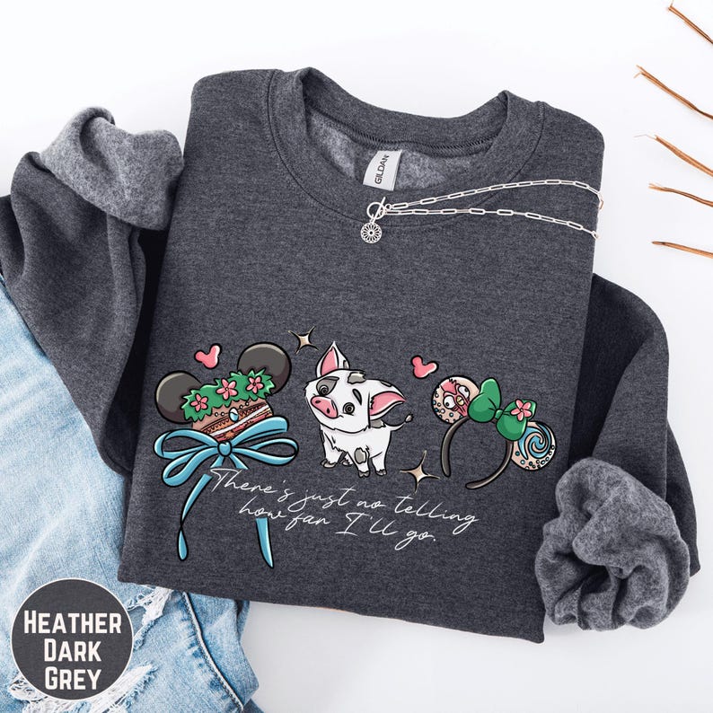 A gray sweatshirt with a graphic design featuring a pig, a bow, and various Disney-themed items, along with the text "There's just no telling how I'll go".