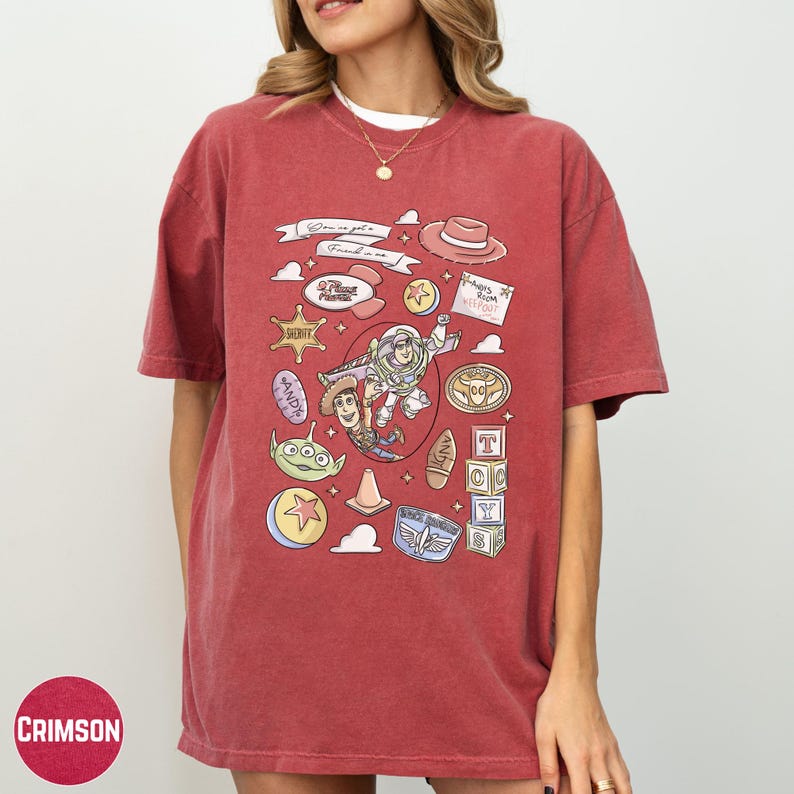 A woman wearing a red t-shirt with various cartoon and pop culture icons printed on it.