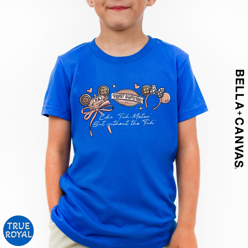 A young boy wearing a blue t-shirt with a Disney-themed graphic and text printed on it.