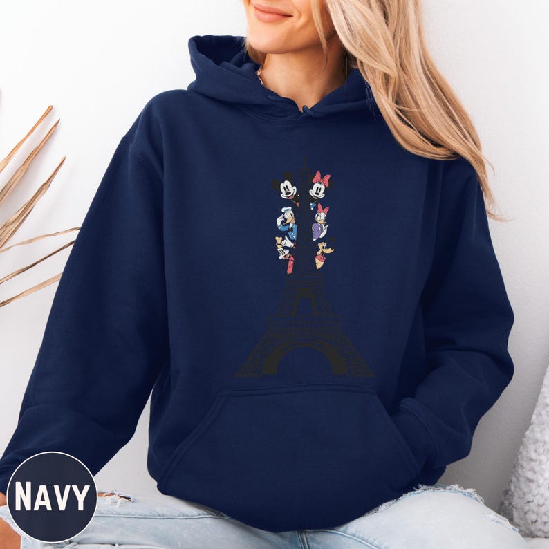 A woman wearing a navy blue hoodie with a graphic of Minnie Mouse and other Disney characters on it.