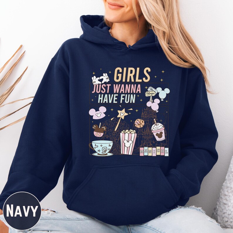 A navy blue hoodie with a graphic design featuring various Disney-themed items such as Mickey Mouse, popcorn, and a castle. The text on the hoodie says "GIRLS JUST WANNA HAVE FUN".