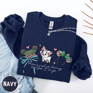 A navy blue sweatshirt with a graphic design featuring a pig, Mickey Mouse ears, and a ribbon, along with the text "There's just no telling how you'll go".