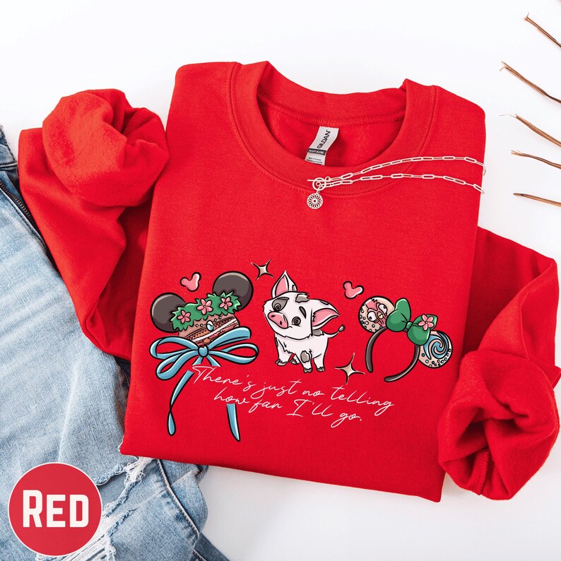 A red sweatshirt with a cartoon pig and various Disney-themed accessories, such as Mickey Mouse ears and a bow, is displayed on a white background.