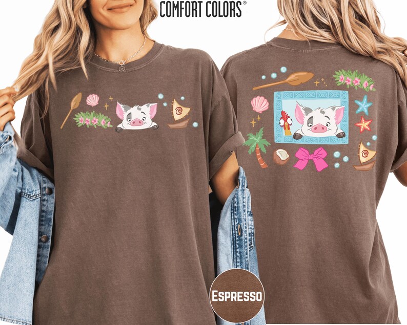 a woman wearing a brown t-shirt with a cartoon pig design and various colorful elements, such as a starfish, seashells, and a palm tree.