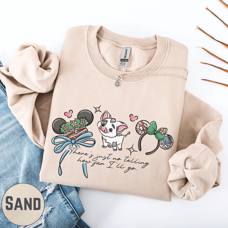 a beige sweatshirt with a cartoon character design, a necklace, and a pair of jeans.