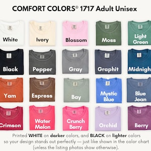 a collection of 1717 adult unisex t-shirts in various colors, including white, ivory, pink, green, black, pepper, gray, graphite, midnight, yam, yam, express, bay, mystical blue, blue jeans, and orchid. The t-shirts are neatly folded and arranged in a grid pattern.