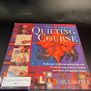 May include: A hardcover book titled The Complete Quilting Course by Gail Lawther. The cover features a large orange and red floral graphic, smaller inset photos of quilting techniques, and a white sticker labeled Vigo County Quilter's Guild 186.