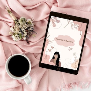 Puede incluir: Una tableta digital que muestra las palabras "Rooted & Radiant" con la silueta de una mujer y detalles florales. Una taza de café blanca con café negro, un pequeño ramo de flores secas y una bufanda rosa también están en la imagen.