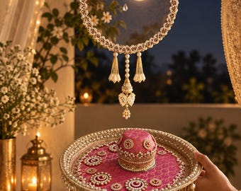 May include: A circular mesh sieve decorated with white pearls and gold beads, featuring hanging pearl tassels. Below, a round pink tray with gold patterns, pearl-encrusted borders, and a central pink dome, finished with dangling pearl fringe.