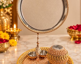 May include: A circular metal sieve with a gold-toned rim, suspended above a round tray decorated with light pink pearls and gold leaf accents. The tray includes two small silver bowls and a matching pearl-covered container with gold leaf detailing.