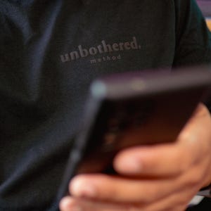 Unbothered Method Black-on-Black Puffy Vinyl Pocket Logo Tee | Minimal Streetwear Unisex T-Shirt | Printed in Hawaiʻi