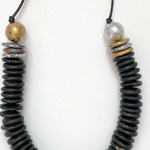Polymer clay long beaded statement necklace sculpted in black clay and strung on leather cord.