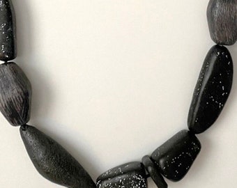 Sculpted and textured black polymer clay bead statement necklace, strung on hand-knotted, leather cord.