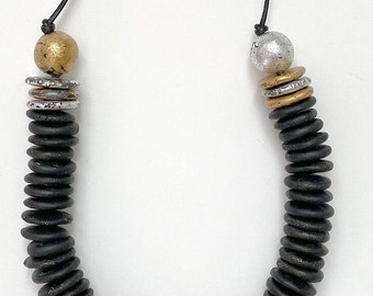 Polymer clay long beaded statement necklace sculpted in black clay and strung on leather cord.