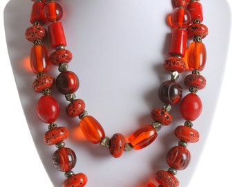 Red bead statement necklace with glass beads, resin beads, coral beads, brass beads, pyrite nugget beads, and bone beads.