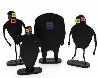 Puede incluir: Cuatro figuras de silueta negra de pie sobre bases ovaladas individuales. Cada figura presenta pequeños acentos cuadrados de colores en la cabeza o el torso, mostrando iconos gráficos simples como ojos, bocas y caras sonrientes en amarillo, rosa y morado.