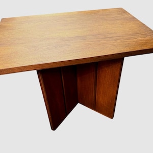 May include: A rectangular wooden side table with a warm brown finish. The table has a solid top and a unique angled base. The table's dimensions are approximately 30 inches long, 20 inches wide, and 20 inches high.