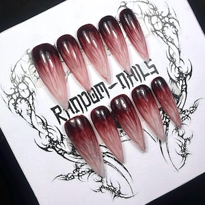Puede incluir: Juego de diez uñas postizas largas en forma de ataúd con un diseño degradado de borgoña oscuro a rosa claro. Las uñas están dispuestas sobre una tarjeta blanca con el texto "Random Nails" y arte lineal negro decorativo.