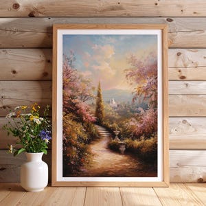 May include: A framed landscape painting depicts a pathway leading to a distant castle. The artwork features a vibrant color palette of pink, green, and blue, with a white vase of flowers in the foreground. The frame is made of light-colored wood.
