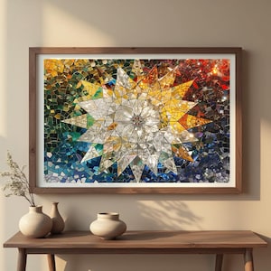 May include: A framed mosaic art piece featuring a starburst design. The artwork is composed of small, colorful tiles in shades of blue, green, yellow, and red. The frame is made of dark wood, and the piece is displayed on a wooden table.