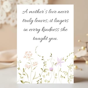 May include: A white card with the text "A mother's love never truly leaves; it lingers in every kindness she taught you." features a floral border with pink and purple flowers and green foliage.