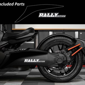 May include: Black motorcycle with the text "RALLY EDITION" in white. The motorcycle has a black tire with orange accents and a black seat. The image also includes a diagram of included parts.