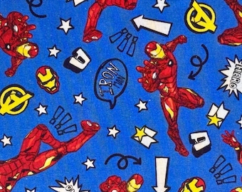 May include: A blue fabric featuring a repeating pattern of Iron Man in red and gold armor, yellow Avengers logos, white stars, black arrows, exclamation marks, and speech bubbles containing the text Iron Man and the word Hero in a starburst.