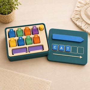Puede incluir: Un juego educativo de color verde azulado oscuro que incluye una bandeja con ranuras numeradas para pilas de fichas de colores, y una tapa a juego con una flecha azul, una línea horizontal y fichas cuadradas que forman la palabra CAT.