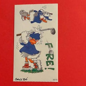 May include: A sticker sheet with a cartoon duck wearing a blue shirt and white feathers, swinging a golf club. The duck is saying "FORE!" and there is a golf ball on the ground. The sticker sheet is from "Saxy's Zoo" and has the number 9679 on it.