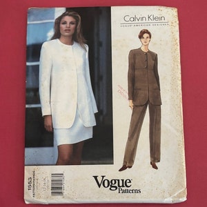 May include: A vintage Vogue sewing pattern for a jacket and skirt set designed by Calvin Klein. The pattern is for size 12-14-16 and is printed on white paper with a black and white illustration of a woman wearing the outfit.