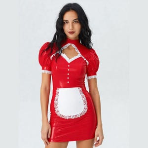 May include: A red, short-sleeved dress with a high collar and a white apron. The dress features white lace trim on the sleeves and apron, and small white buttons down the front. The dress is made of a shiny material.