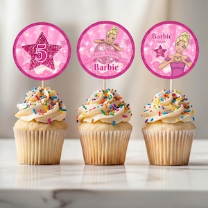 May include: Three cupcakes with white frosting and colorful sprinkles. Each cupcake has a pink topper with a Barbie theme. One topper has a glittery star with the number 5, another says "Happy Birthday Barbie", and the last says "Barbie turns 5".