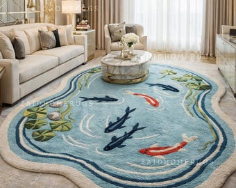 Könnte beinhalten: Hellblauer, teichförmiger Teppich mit cremefarbenem Rand. Der Teppich zeigt ein Design von Koi-Karpfen in Rot und Marineblau, mit Seerosen und Wasserpflanzen. Der Teppich befindet sich in einem Wohnzimmer.