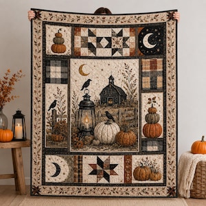May include: A rectangular quilt featuring a central scene of a dark barn, a lit lantern, crows, and pumpkins. The border displays star patterns, crescent moons, and plaid blocks in shades of orange, black, brown, and cream with leaf motifs.