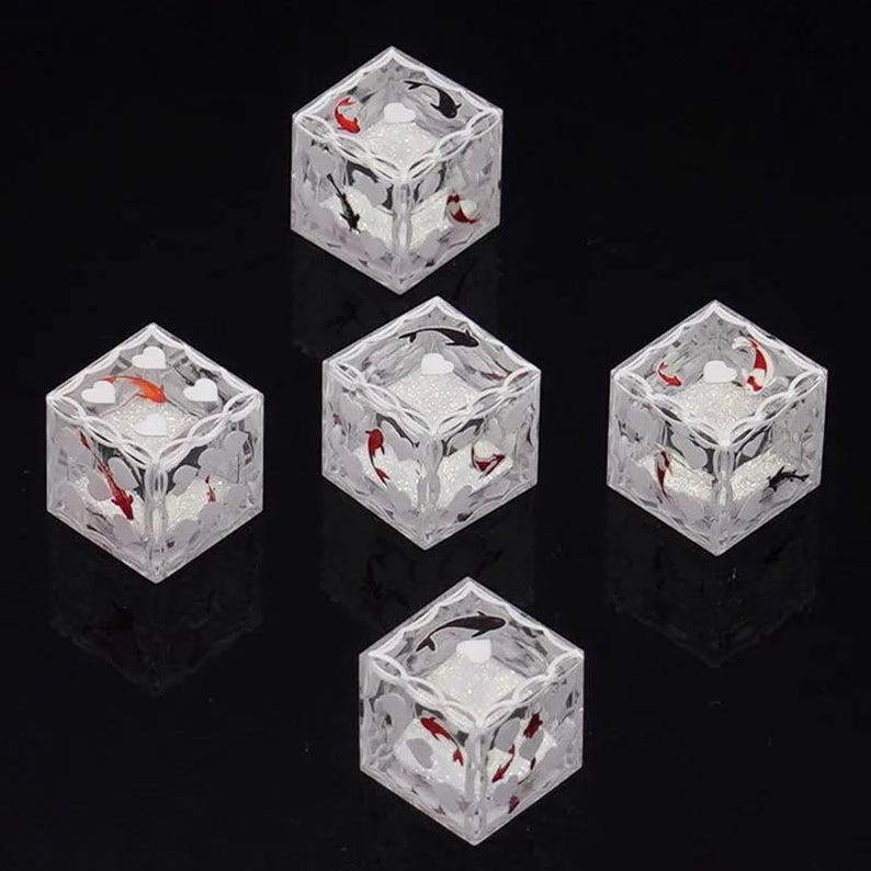 May include: Five clear, transparent cubic blocks featuring internal designs of red, white, and black koi fish swimming among white heart shapes. Each cube has a textured, glittery white base and a decorative white lattice pattern on the top edges.
