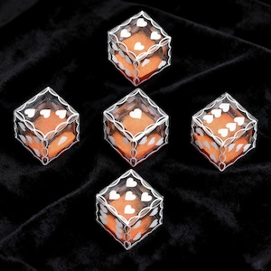 May include: Five clear plastic cube-shaped boxes, each containing a bright orange square insert. The exterior of each box features a white printed pattern of interconnected loops and small heart shapes on the top and side faces.