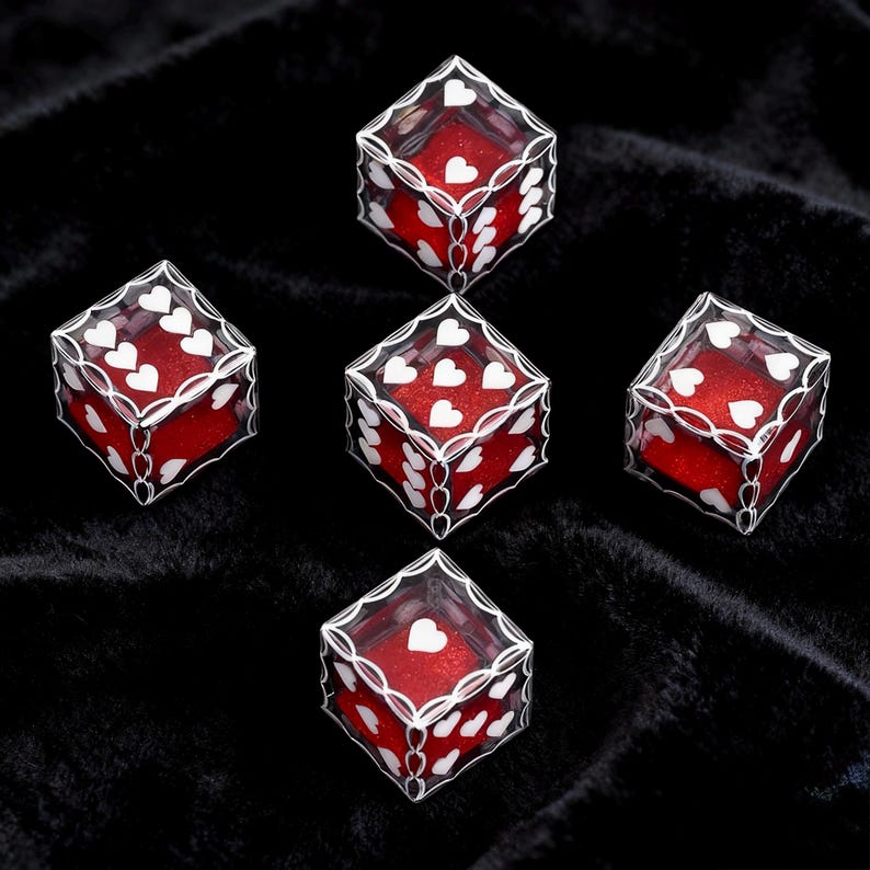 May include: Five six-sided dice featuring a clear outer shell with white heart-shaped pips and a red glittery interior. Each die displays a different number of white hearts on its faces, arranged in a standard dice configuration on a black surface.