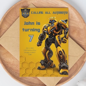 Op de afbeelding: Een gele verjaardagsuitnodiging met een illustratie van een robot. De tekst luidt "CALLING ALL AUTOBOTS!" en "John wordt 7". De uitnodiging bevat ook de datum en tijd van het evenement.