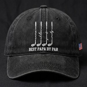 May include: Dark grey baseball cap featuring white embroidered golf clubs and names: Anna, Chloe, Jennifer, and Emily. The text "BEST PAPA BY PAR" is below the golf clubs. An American flag patch is on the side.
