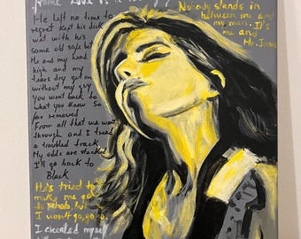 May include: A canvas painting featuring a stylized portrait of a woman in yellow and black against a gray background. The artwork includes handwritten song lyrics. The painting's theme appears to be related to music and art.