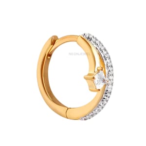 Könnte beinhalten: Goldfarbener Creolen-Ohrring mit einer Reihe kleiner, klarer Steine. Ein quadratischer, klarer Stein ist in der Mitte eingesetzt. Der Text "NEONJEWEL" ist auf dem Ohrring sichtbar.