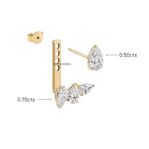 Op de afbeelding: Een gouden ear jacket oorbellen set met een peervormige diamantstud van 0,50cts en een verticale staaf met drie peervormige diamanten van 0,70cts. Het sieraad bevat een losse achterkant en de tekst NEONJEWEL.