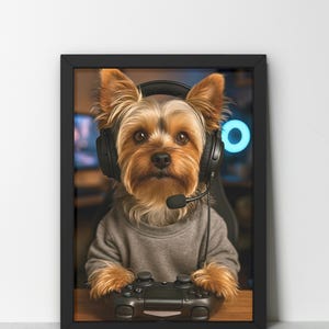 Pu&ograve; includere: Stampa incorniciata con un Yorkshire Terrier che indossa una cuffia con microfono e tiene in mano un controller per videogiochi. Il cane indossa un maglione grigio. Lo sfondo presenta una configurazione di gioco sfocata.